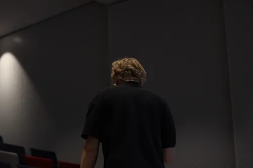 Teilnehmer geht durch einen Flur des Veranstaltungsgebäudes und lächelt in die Kamera.