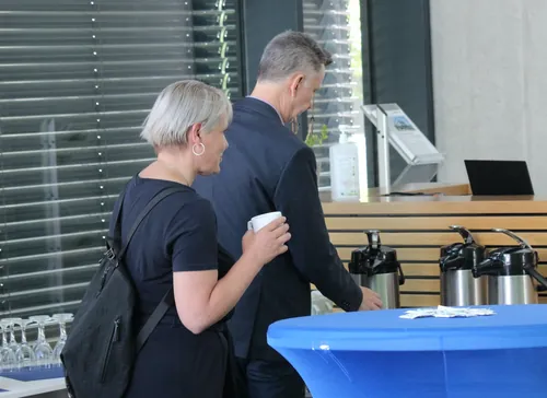 Porträt eines Teilnehmers im Anzug im Foyer der Veranstaltung.