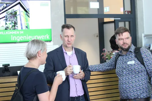 Nahaufnahme: Mann und Frau im Gespräch, grüner Hintergrund.