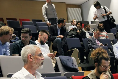 Teilnehmer einer Konferenz während einer Diskussionspause im Hörsaal.