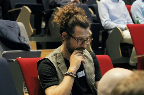 Besucher einer Fachveranstaltung sitzen in einem Hörsaal und tauschen sich aus.